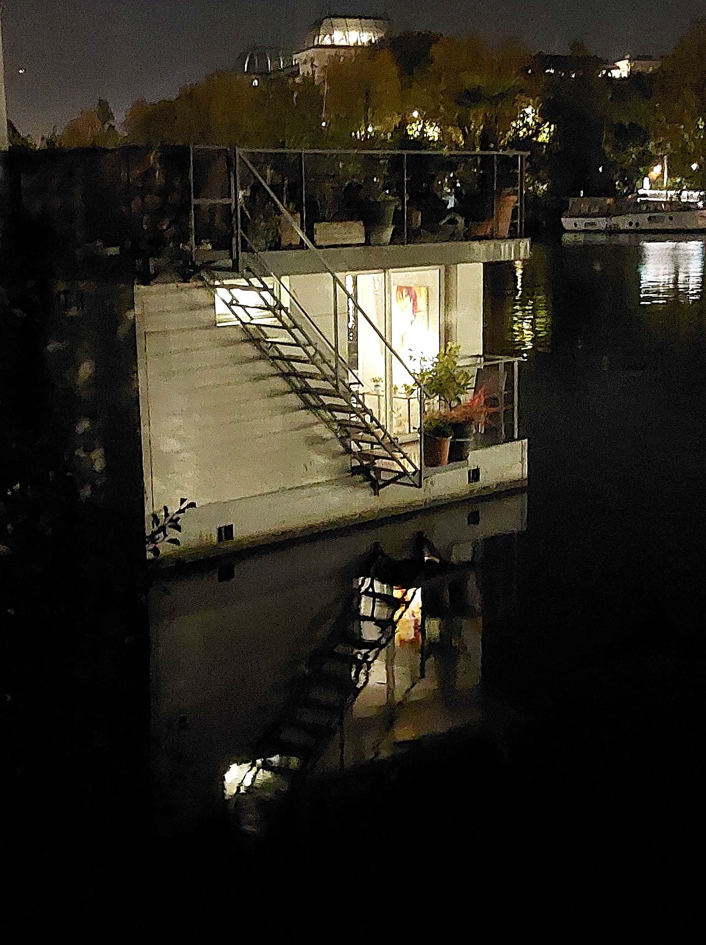 La maison flottante éclairée de nuit, au bord du parc nautique