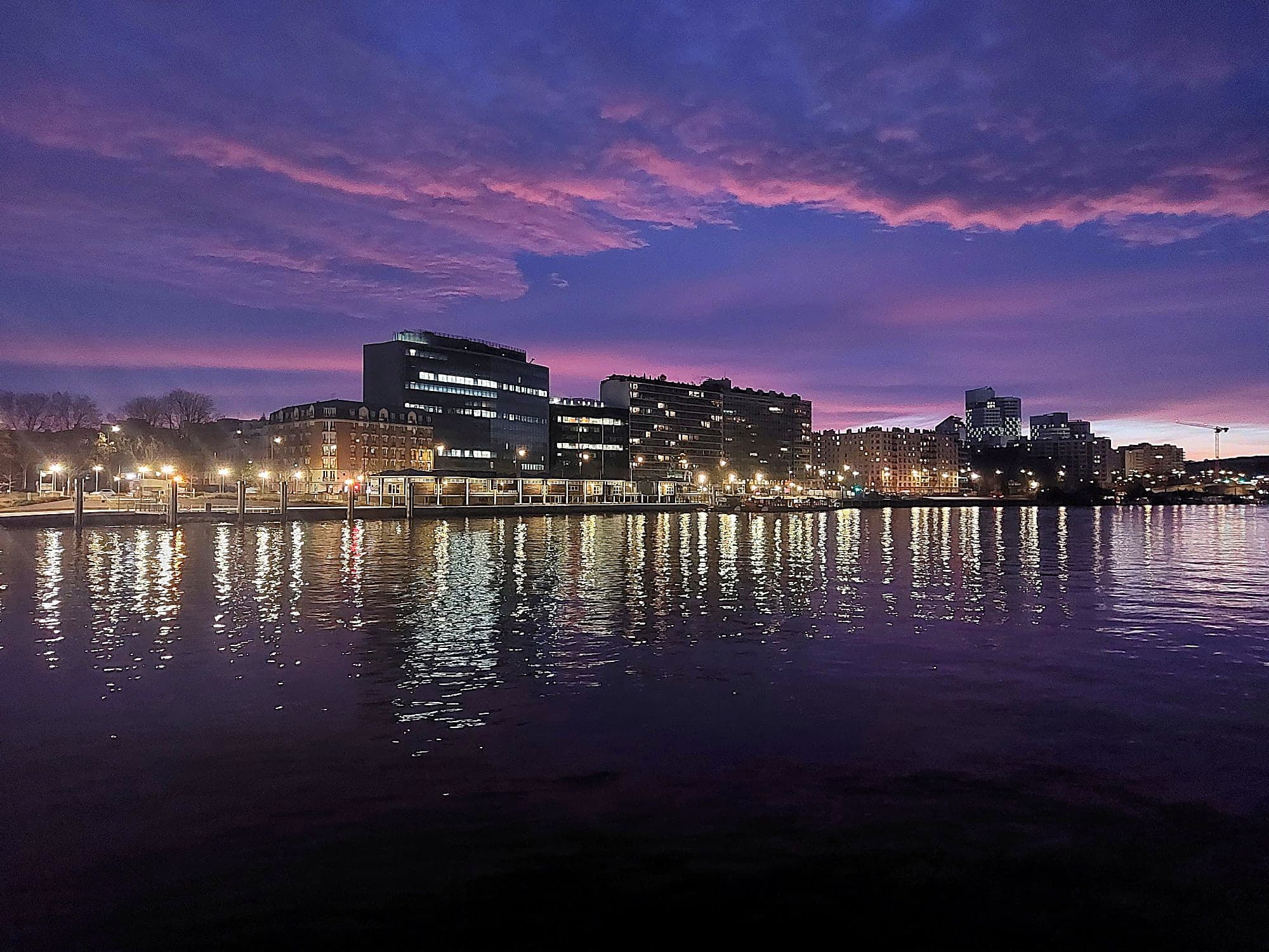 La Seine au crépuscule depuis le mouillage de Megalight II, les rives illuminées se reflétant sur l'eau